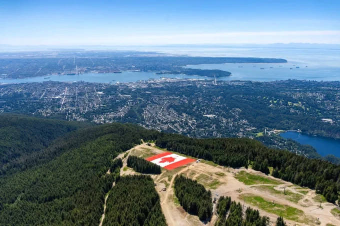 Quốc kỳ Canada tại n&uacute;i Grouse Mountain ph&iacute;a tr&ecirc;n th&agrave;nh phố Vancouver. Ảnh: Reuters