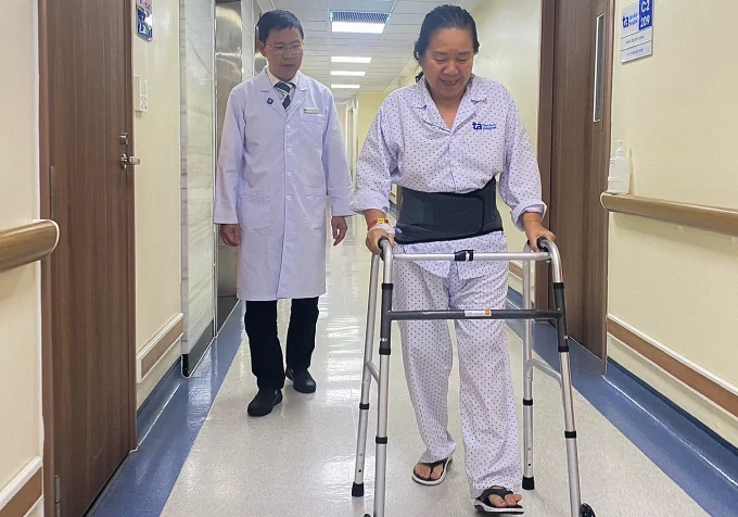 Bác sĩ Hiển hướng dẫn người bệnh tập đi lại sau mổ. Ảnh: Bệnh viện Đa khoa Tâm Anh