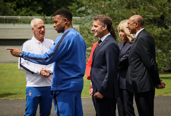 HLV tuyển Pháp, Didier Deschamps và đội trưởng Kylian Mbappe (áo xanh) tiếp vợ chồng Tổng thống Pháp và Chủ tịch Liên đoàn bóng đá Pháp tại trại huấn luyện ở Paris, hôm 2/6. Ảnh: AP