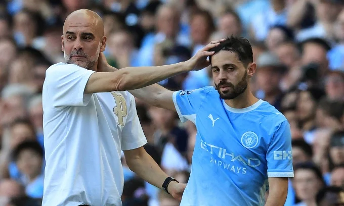 HLV Pep Guardiola của Man City ôm tiền vệ Bernardo Silva khi cầu thủ người Bồ Đào Nha rời sân trong trận Man City gặp Aston Villa tại Ngoại hạng Anh trên sân Etihad, Manchester, Anh ngày 24/5/2026. Ảnh: AFP