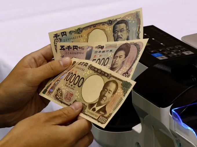Một nhân viên cầm tiền mẫu tại Nhà máy In tiền Quốc gia Nhật Bản. Ảnh: Reuters