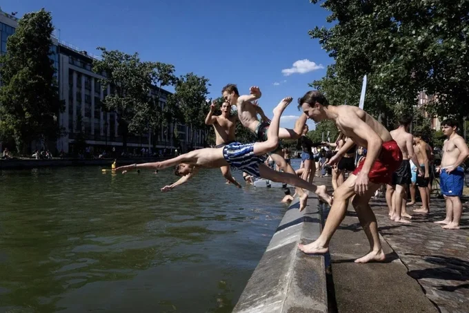 Những người trẻ tuổi đang lặn xuống Bassin des Recollets, trên kênh đào Saint-Martin ở Paris, vào ngày 17/6. ẢNH: AFP