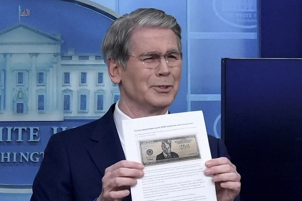 Bộ trưởng Tài chính Scott Bessent cầm mẫu thiết kế tờ tiền 250 USD có hình Tổng thống Trump trong họp báo tại Nhà Trắng hồi tháng 5. Ảnh: AP