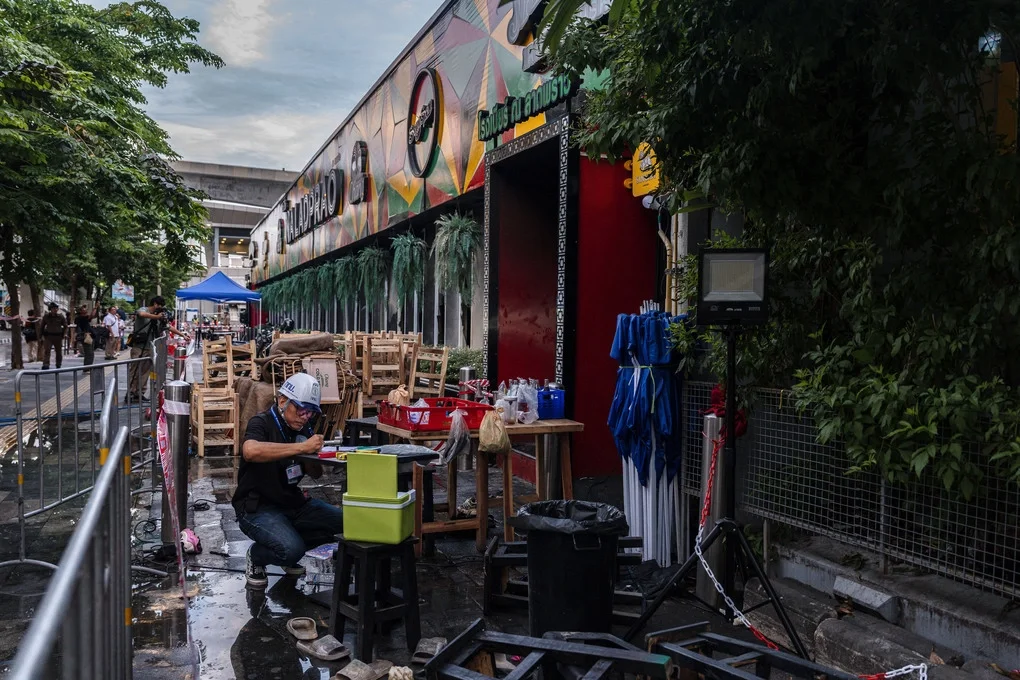 Các quan chức thuộc Cơ quan Quản lý Đô thị Bangkok làm việc bên ngoài quán pub, sau khi ngọn lửa được khống chế ngày 13/7. Ảnh: AFP