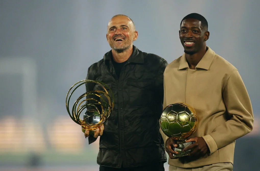 HLV Luis Enrique cùng tiền đạo Ousmane Dembele khoe phần thưởng cho HLV hay nhất và Quả Bóng Vàng sau trận PSG - Auxerre trên sân Parc des Princes, Paris, ngày 27/9/2025. Ảnh: Reuters
