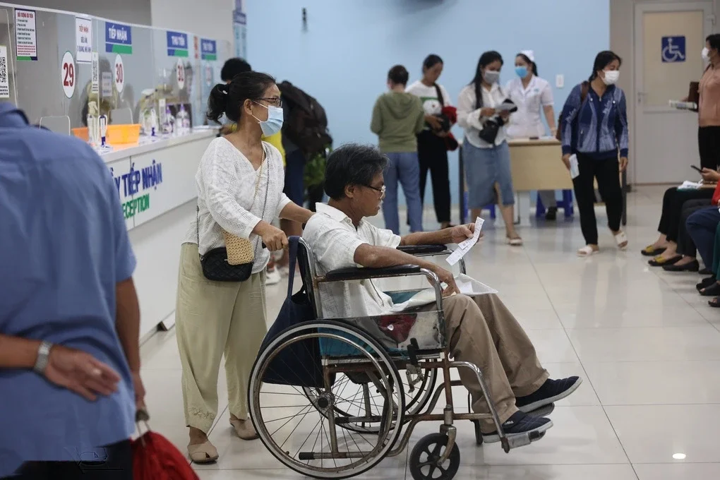 Bệnh nhân ngồi xe lăn chờ khám bệnh tại bệnh viện ở TP HCM. Ảnh: Quỳnh Trần