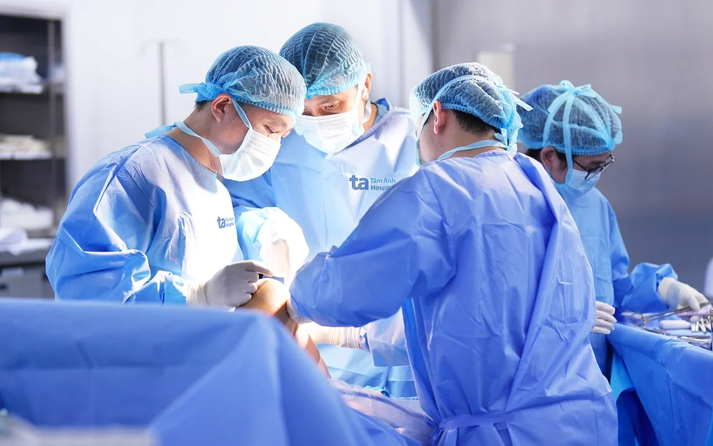 Bác sĩ Nghĩa (trái) phẫu thuật cho người bệnh đứt dây chằng. Ảnh: Bệnh viện Đa khoa Tâm Anh