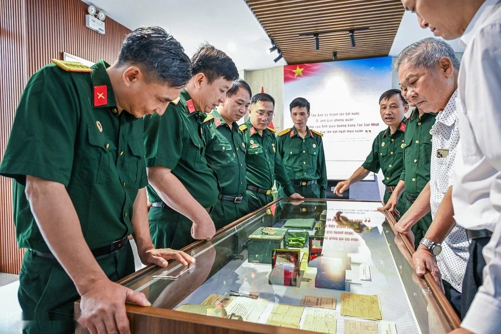 Ông Việt Anh (áo chấm bi) cùng các quân nhân xem hồ sơ, kỷ vật tại trưng bày. Ảnh: Giang Huy