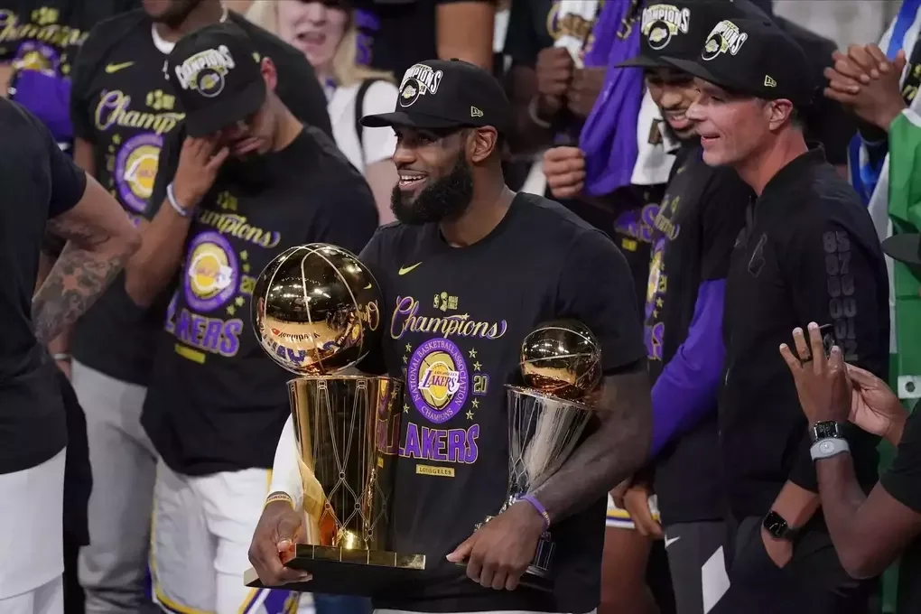 LeBron James (giữa) cầm các danh hiệu vô địch và mừng cùng đồng đội sau khi Los Angeles Lakers đánh bại Miami Heat 106-93 ở Game 6 NBA Finals tại Lake Buena Vista, Florida, Mỹ ngày 11/10/2020. Ảnh: AP